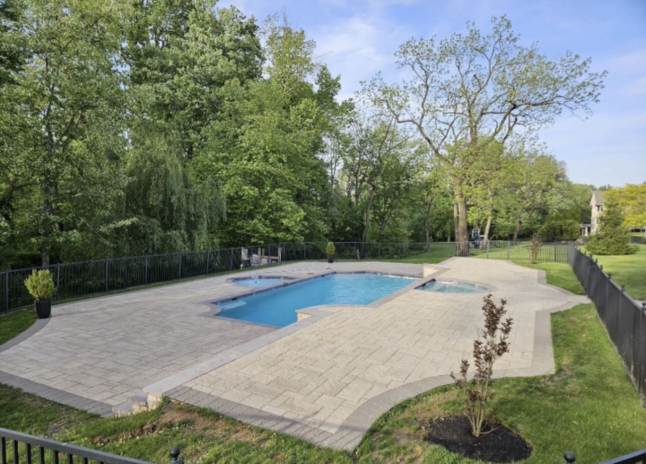 Wide view of renovated pool and expansive new paver deck