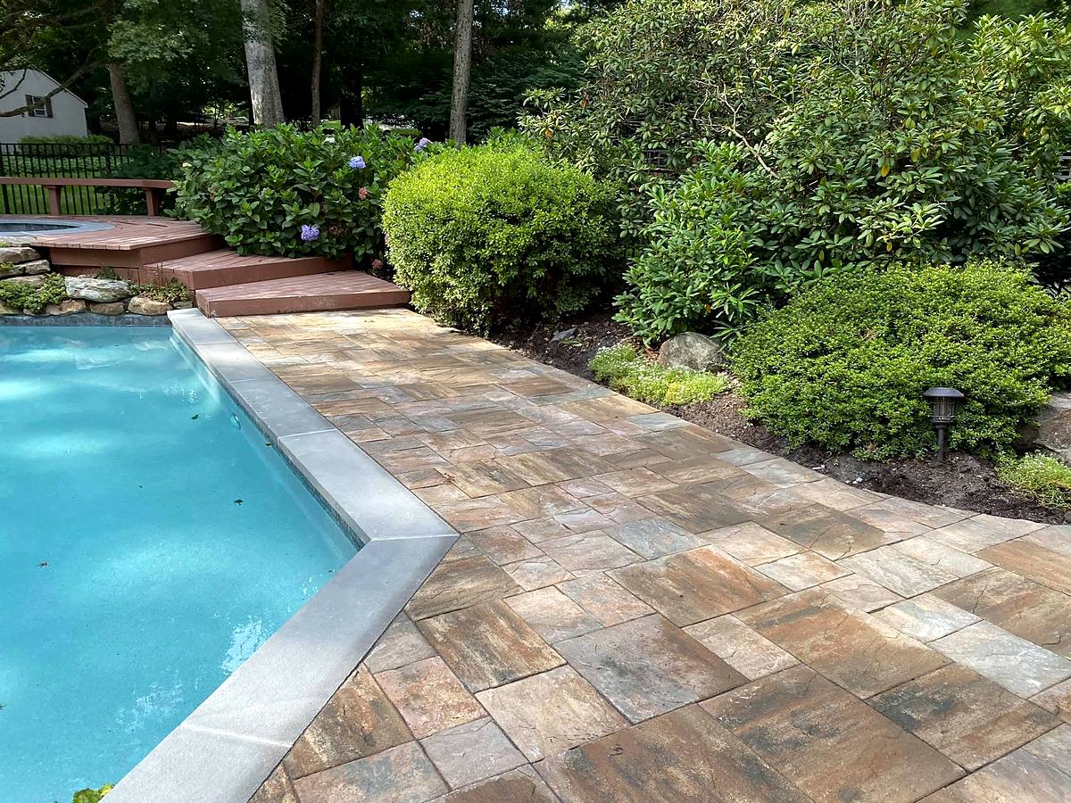 Paver pool deck meeting bluestone coping, with new steps and plantings