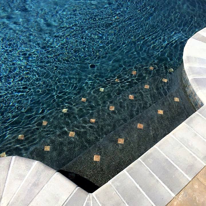 Close view of new waterline tile, glass accent tiles and travertine coping