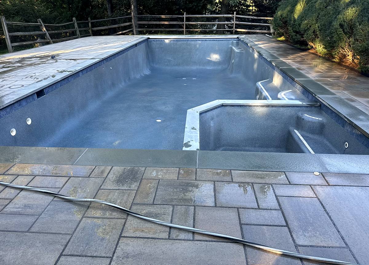Pool and spa in bond coat with new bluestone coping and paver deck, ready for plaster