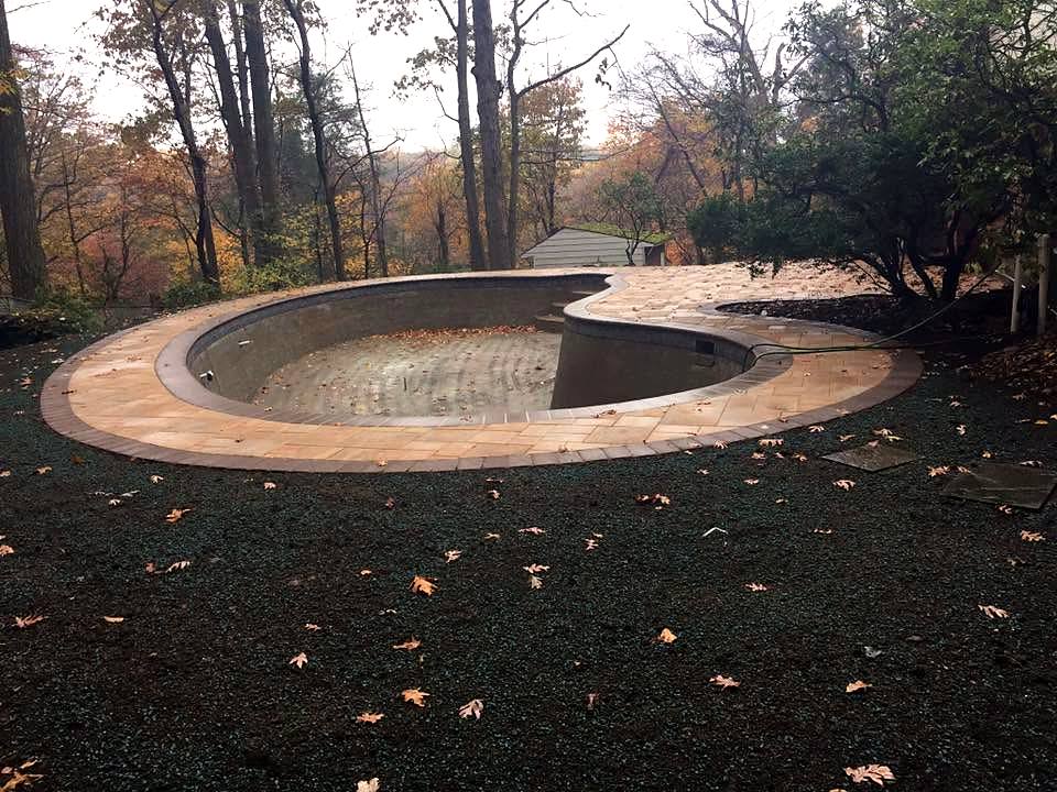 Empty freeform pool with new stone coping set, before tile and plaster