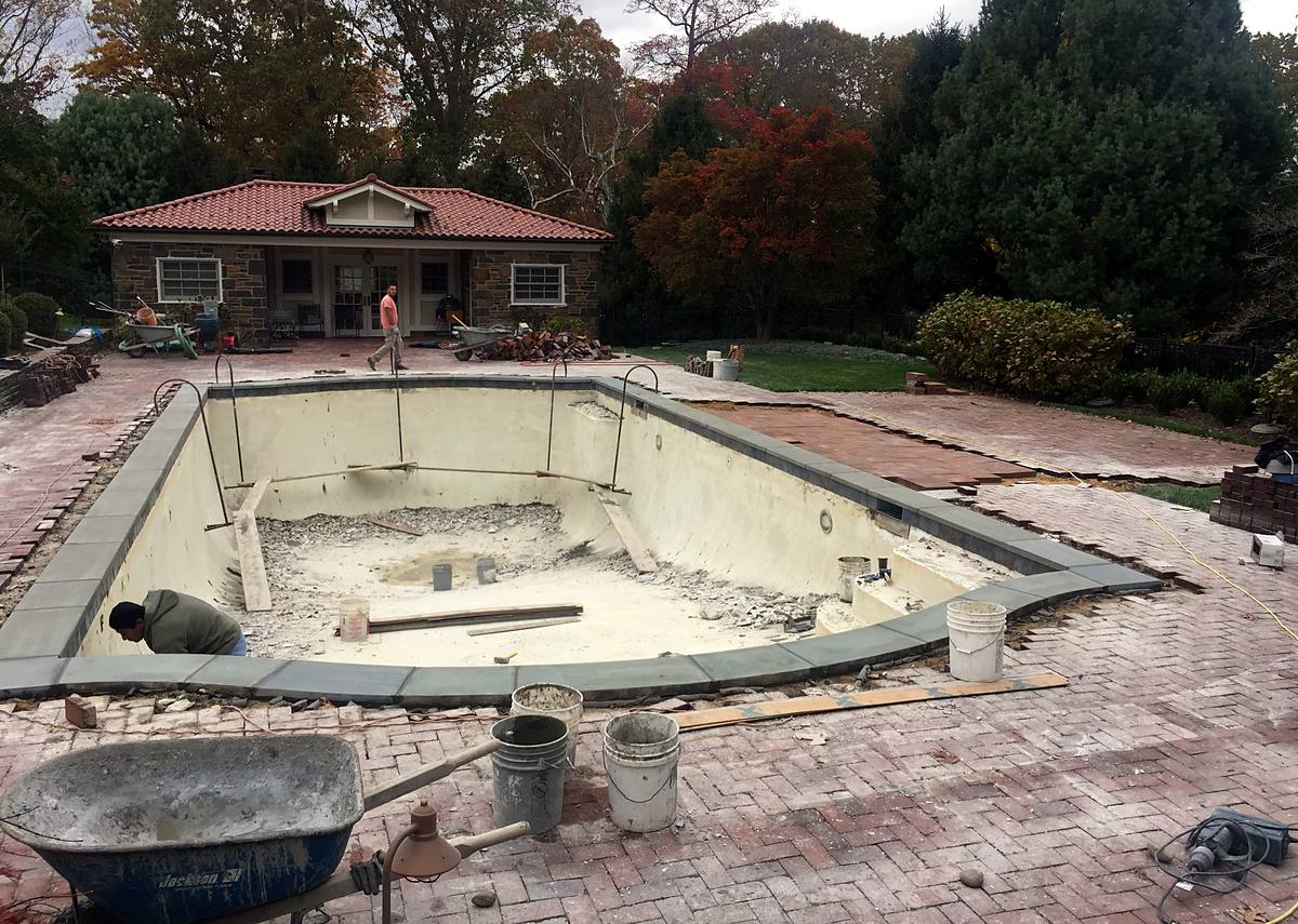 Old tile and plaster being chipped out of a pool before renovation