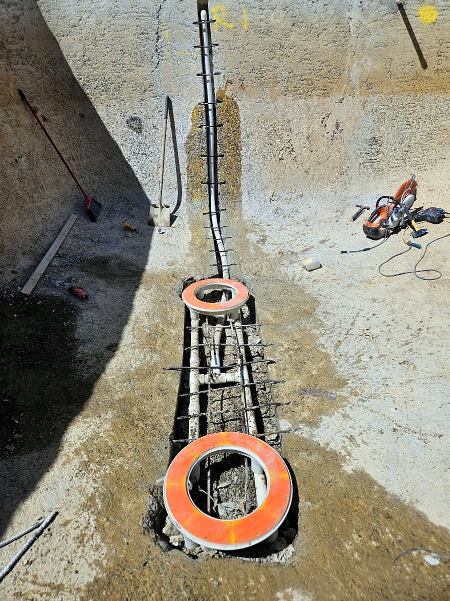 New main drain plumbing set in the floor of a gunite pool shell