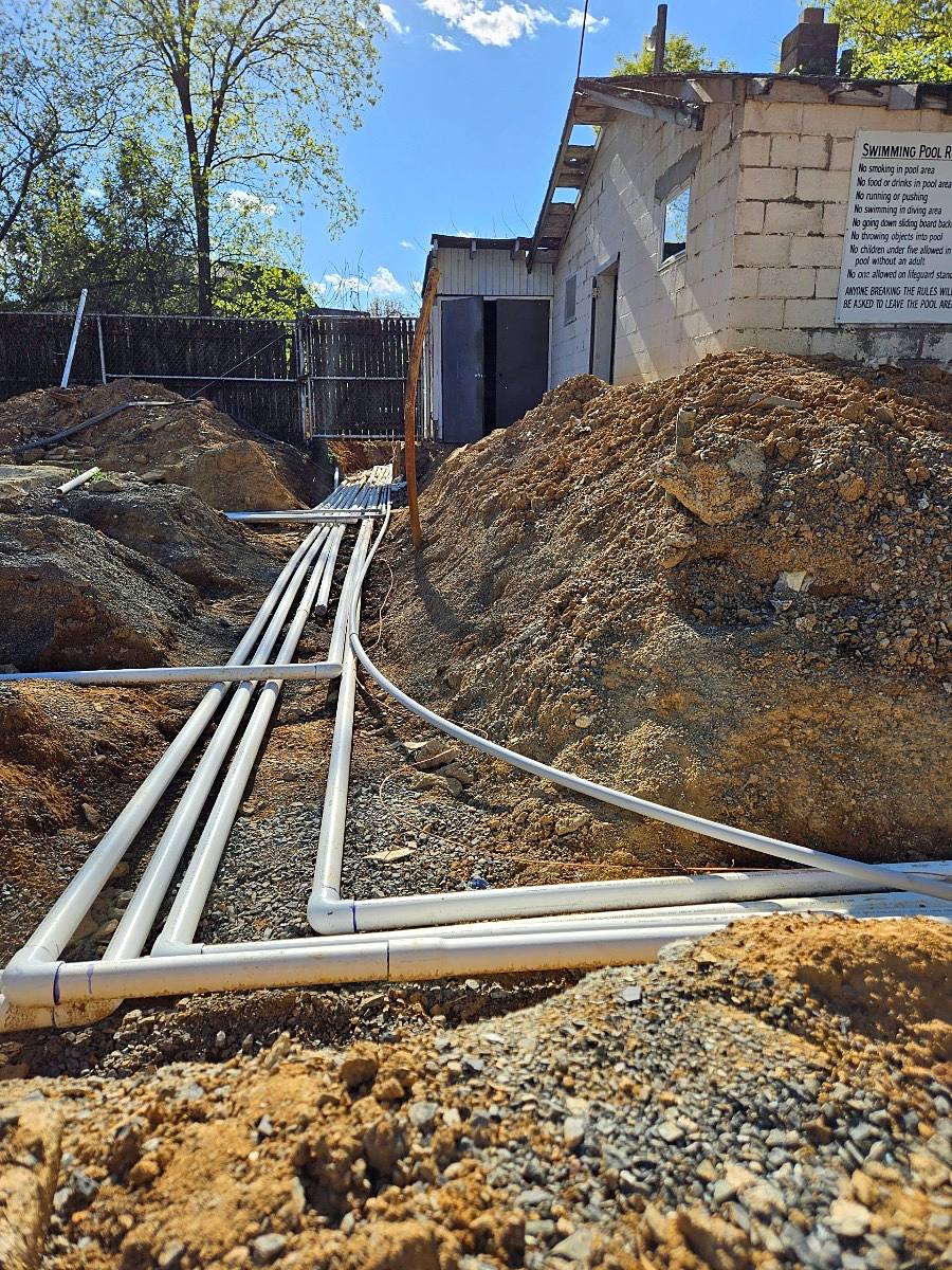 New PVC pool plumbing lines running in a trench to the equipment pad